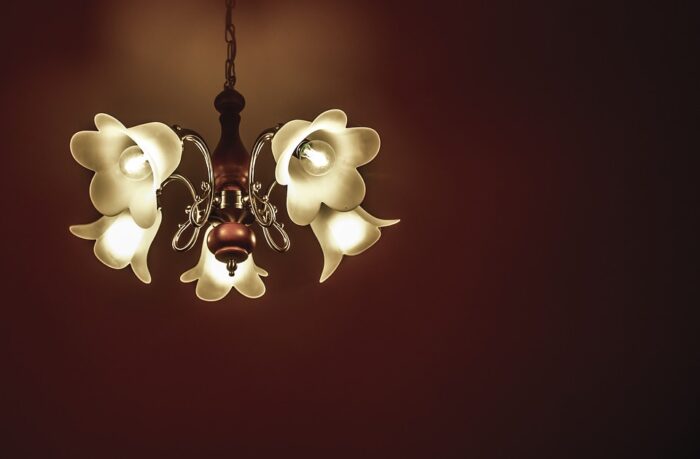 A chandelier with white flowers hanging from it, perfect for small space décor.
