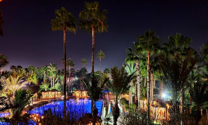 A resort with palm trees and a pool at night in Marrakech, Morocco.