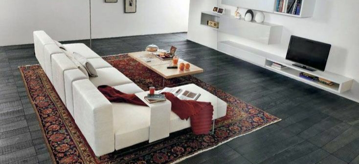 A living room with a white couch and a Persian rug.