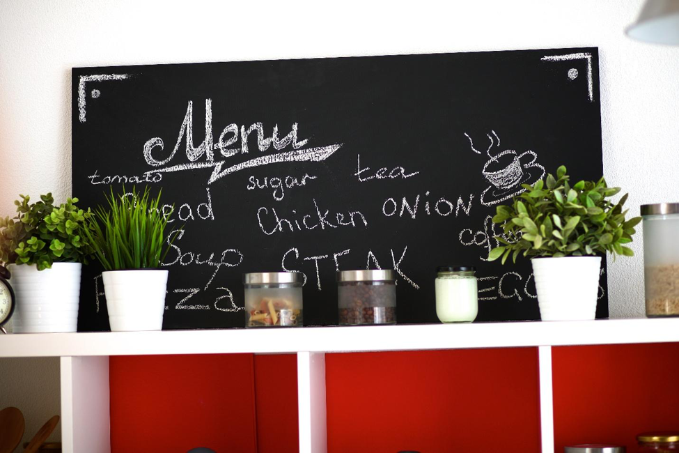 A kitchen with a chalkboard menu and potted plants, ideal for kitchen wall decor.