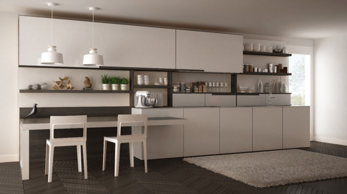 A modern kitchen with white cabinets and a table, featuring a breakfast bar.