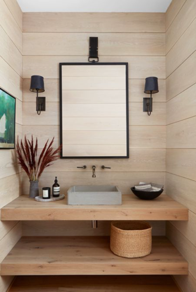 A bathroom with wood paneling and extra storage.
