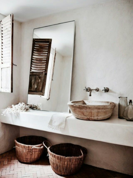 A bathroom with a floating vanity and wicker baskets.