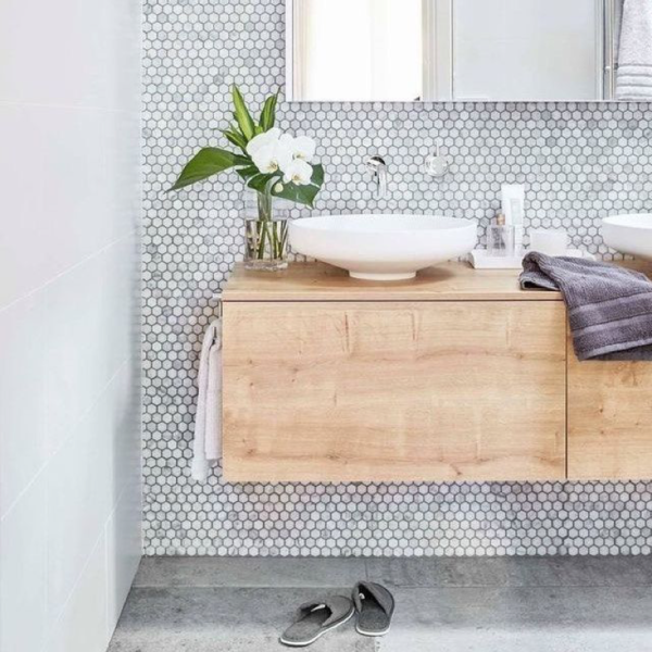 A bathroom with a white floating vanity and white tiled walls.