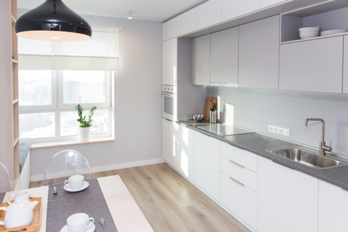 A white Scandinavian kitchen with gray cabinets.