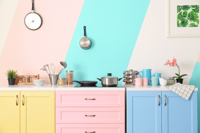 A colorful kitchen with blue and pink walls.