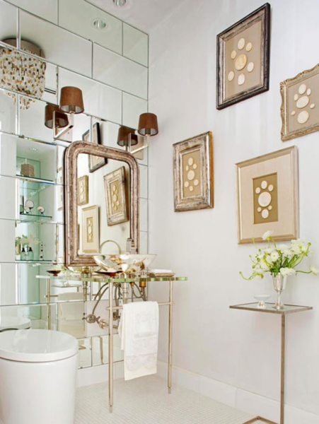 A white bathroom with mirrors and framed pictures designed for Bathroom Design.