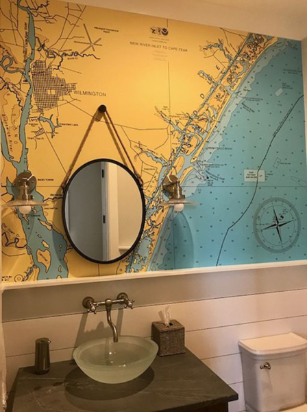 A bathroom with a map wallpaper on the wall.