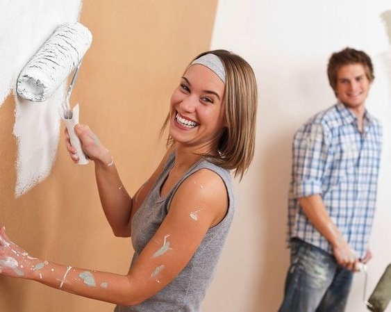 A man and woman painting walls.