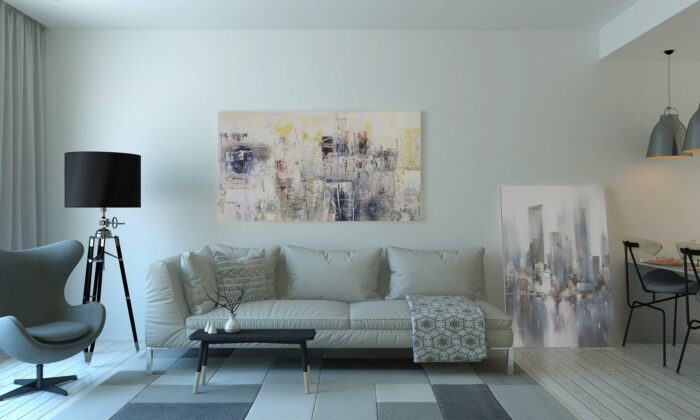 A white living room with a grey couch perfect for buying art.