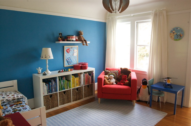 Child's bedroom with blue walls and a teddy bear.