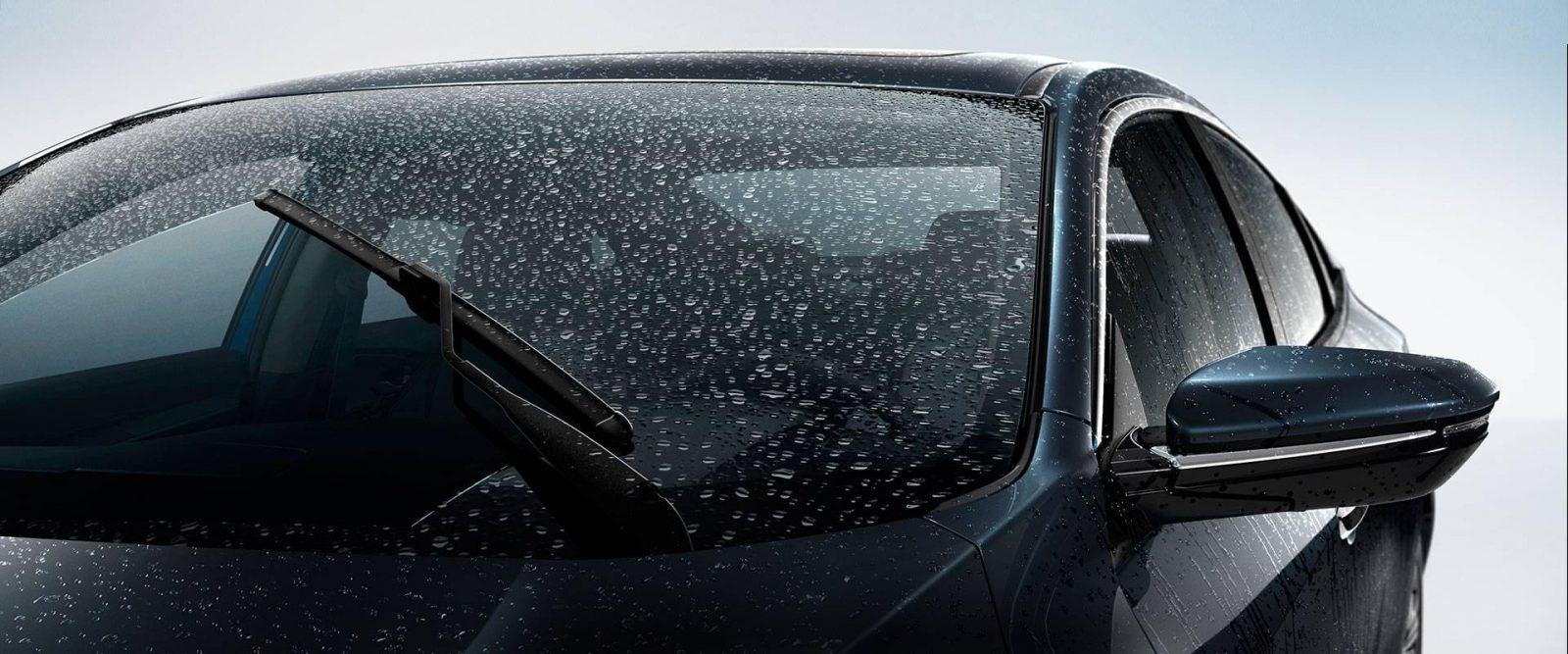 A car windshield with rain on it equipped with silent windshield wipers.
