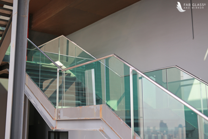 A tempered glass stair railing in a building.