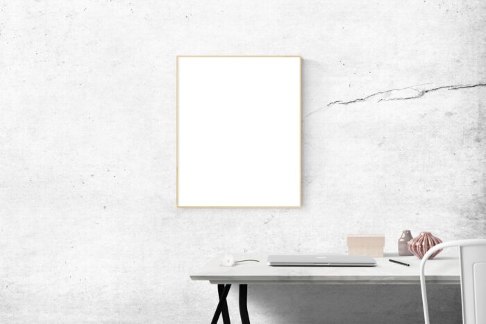 A white frame on a concrete wall in an office mockup showcasing small space hacks.