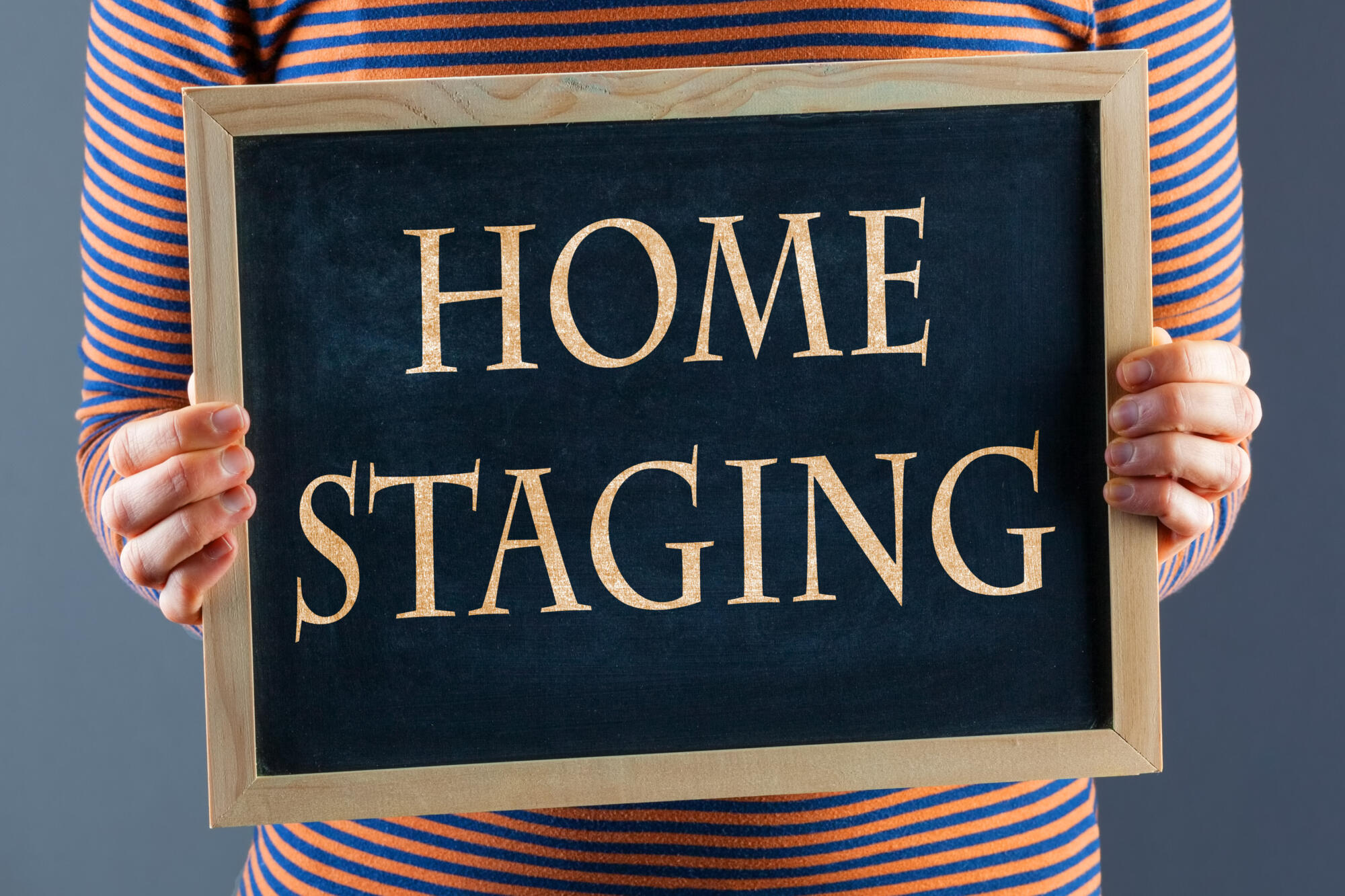 A woman debunking home staging myths by holding up a sign.