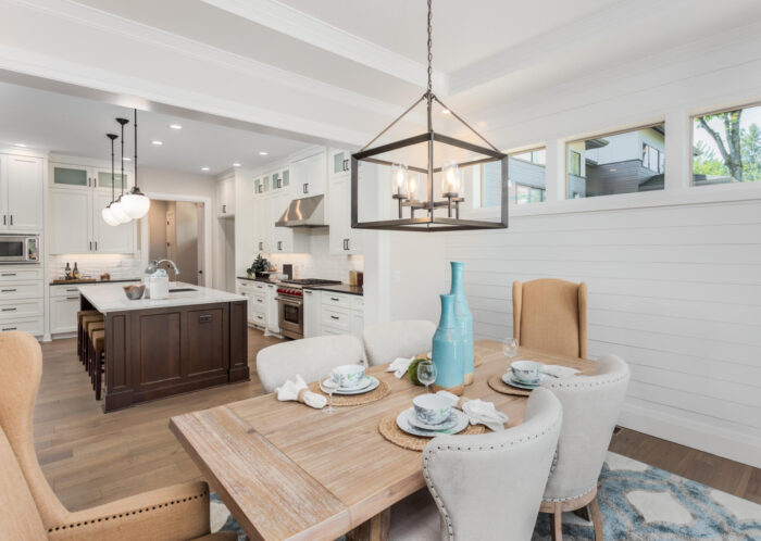 A white kitchen with a dining table and chairs for home staging.