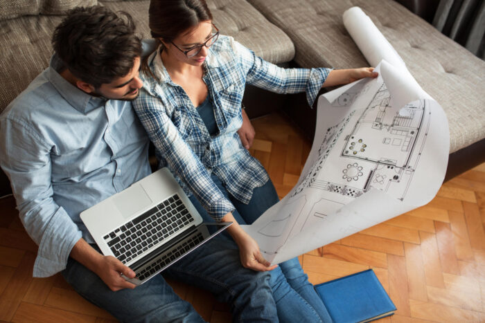 Young couple examining blueprints of they new house.