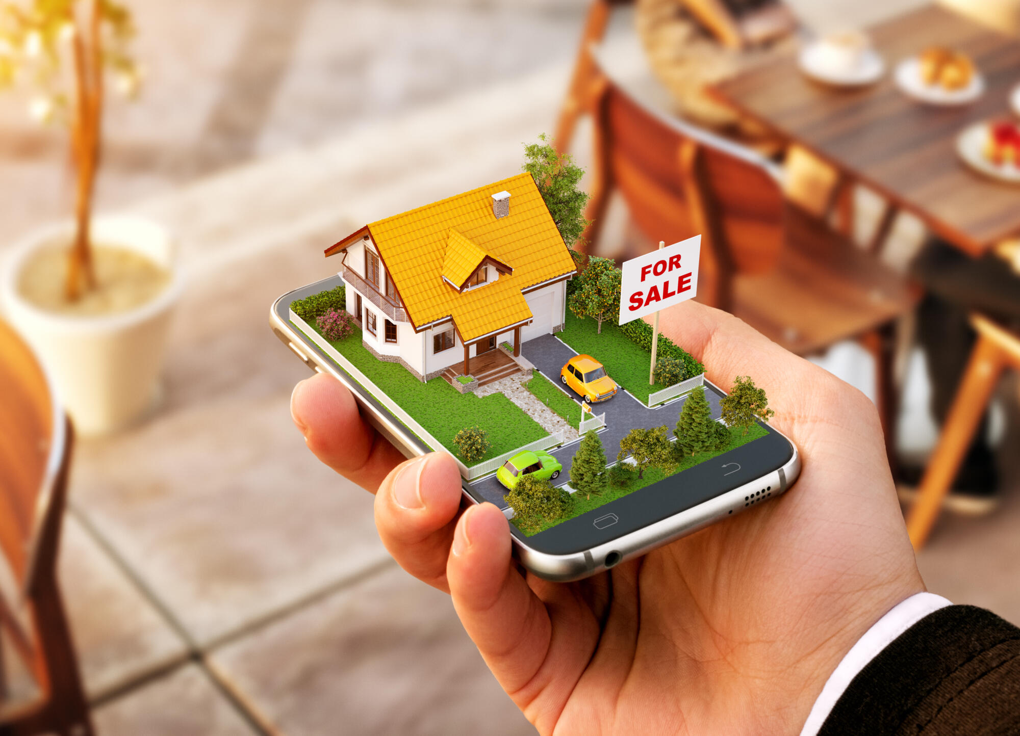 A property sales agent showcasing a house model on a smartphone.