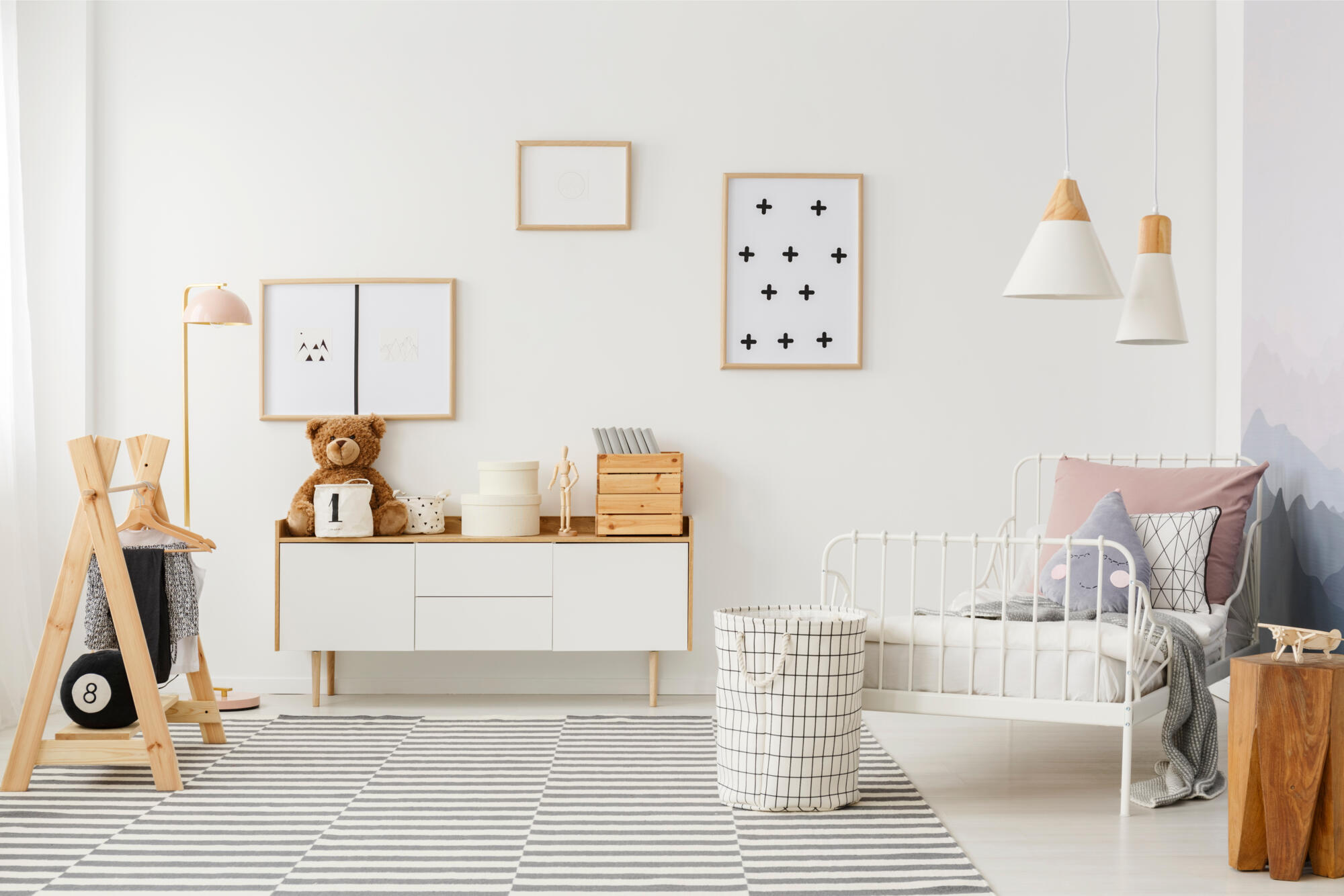 A kids’ bedroom with white furniture and a teddy bear.