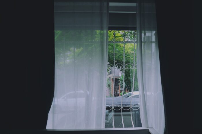 A small room window with a white curtain.