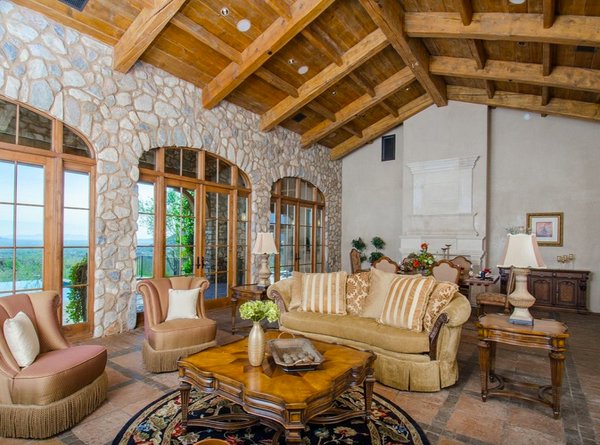 Tuscan living room with stone walls and a fireplace.