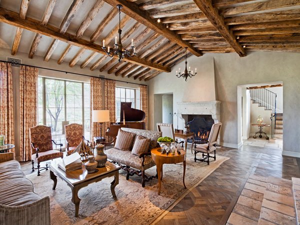 A Tuscan living room with wood beams and a fireplace.