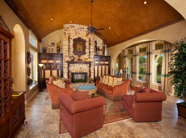 A Tuscan living room with an ornate ceiling and a fireplace.