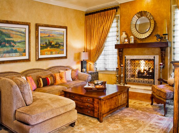 A Tuscan living room with beige walls and a fireplace.