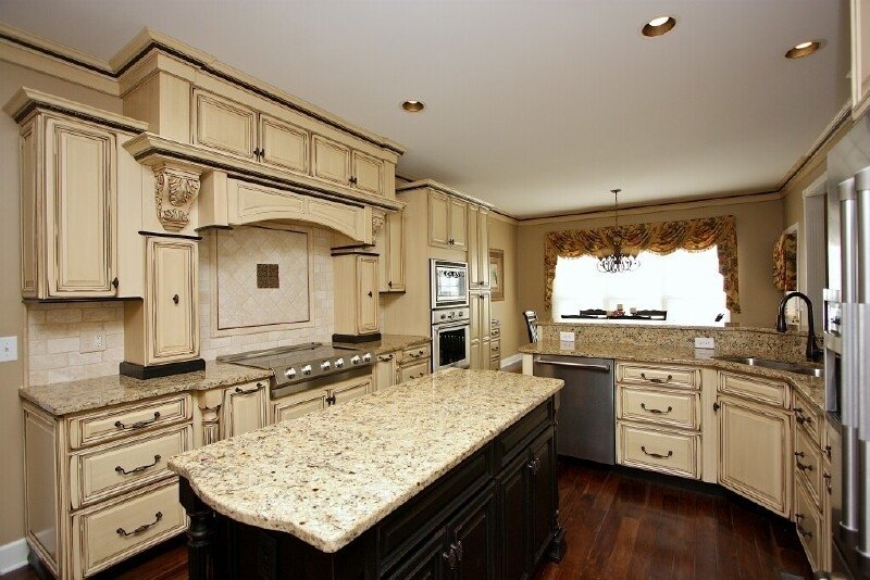A kitchen with antique white cabinets and granite counter tops.