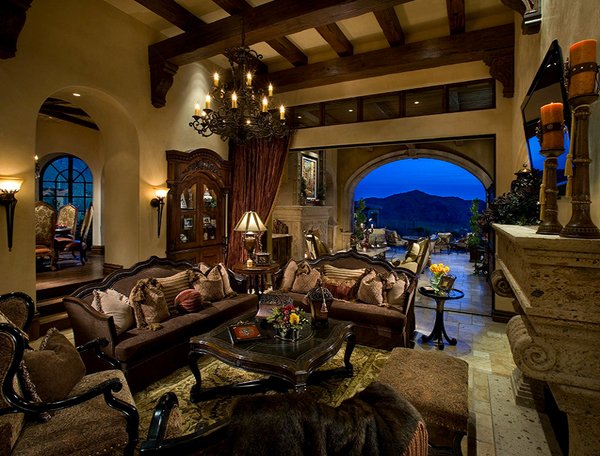 A large Tuscan living room with ornate furniture and a fireplace.