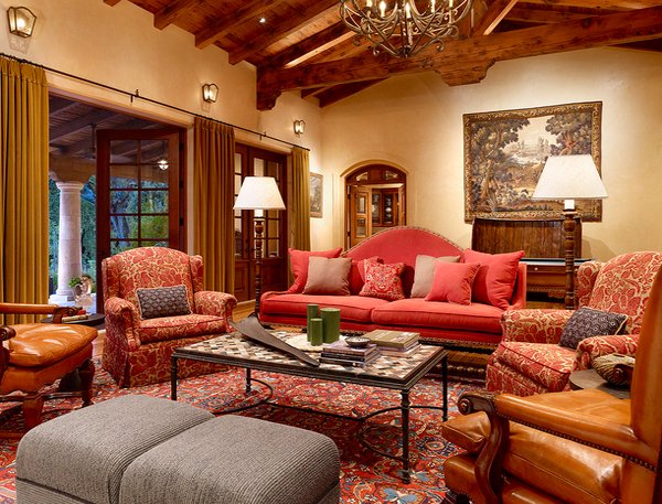 A Tuscan living room with red furniture and a chandelier.