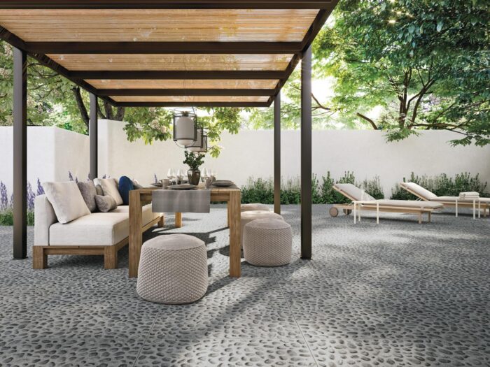 An outdoor patio with furniture and a pergola featuring outdoor porcelain tiles.