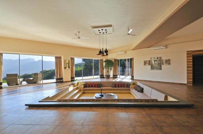 A sunken living room with large windows.