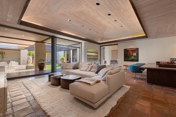A modern living room with a wooden ceiling, incorporating bar ideas.