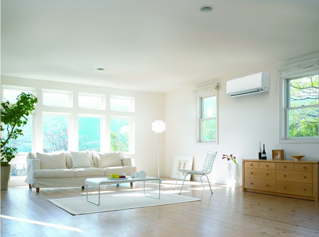 A living room with white furniture and a window, equipped with home air conditioning.