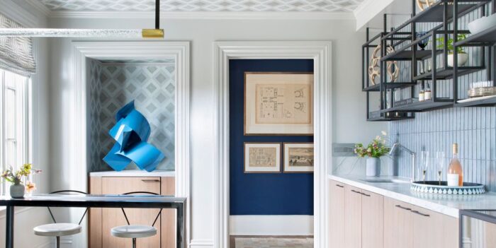 A kitchen with blue walls and bar stools.
