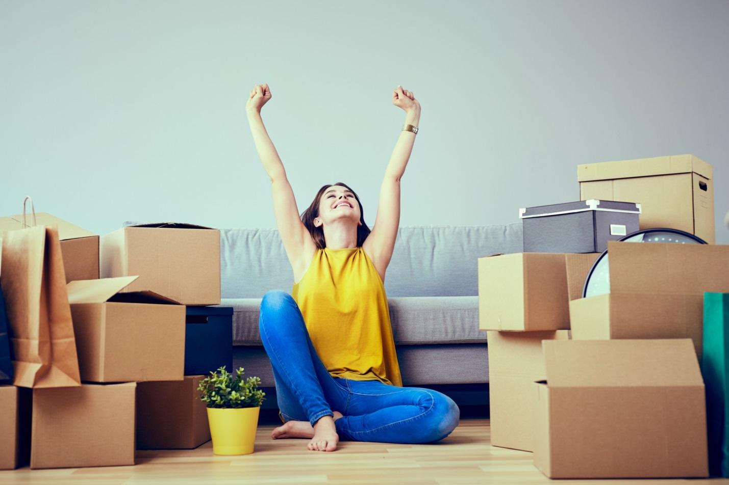 A woman surrounded by moving boxes, organizing house essentials.