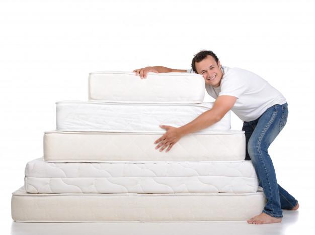 A man resting on mattresses.