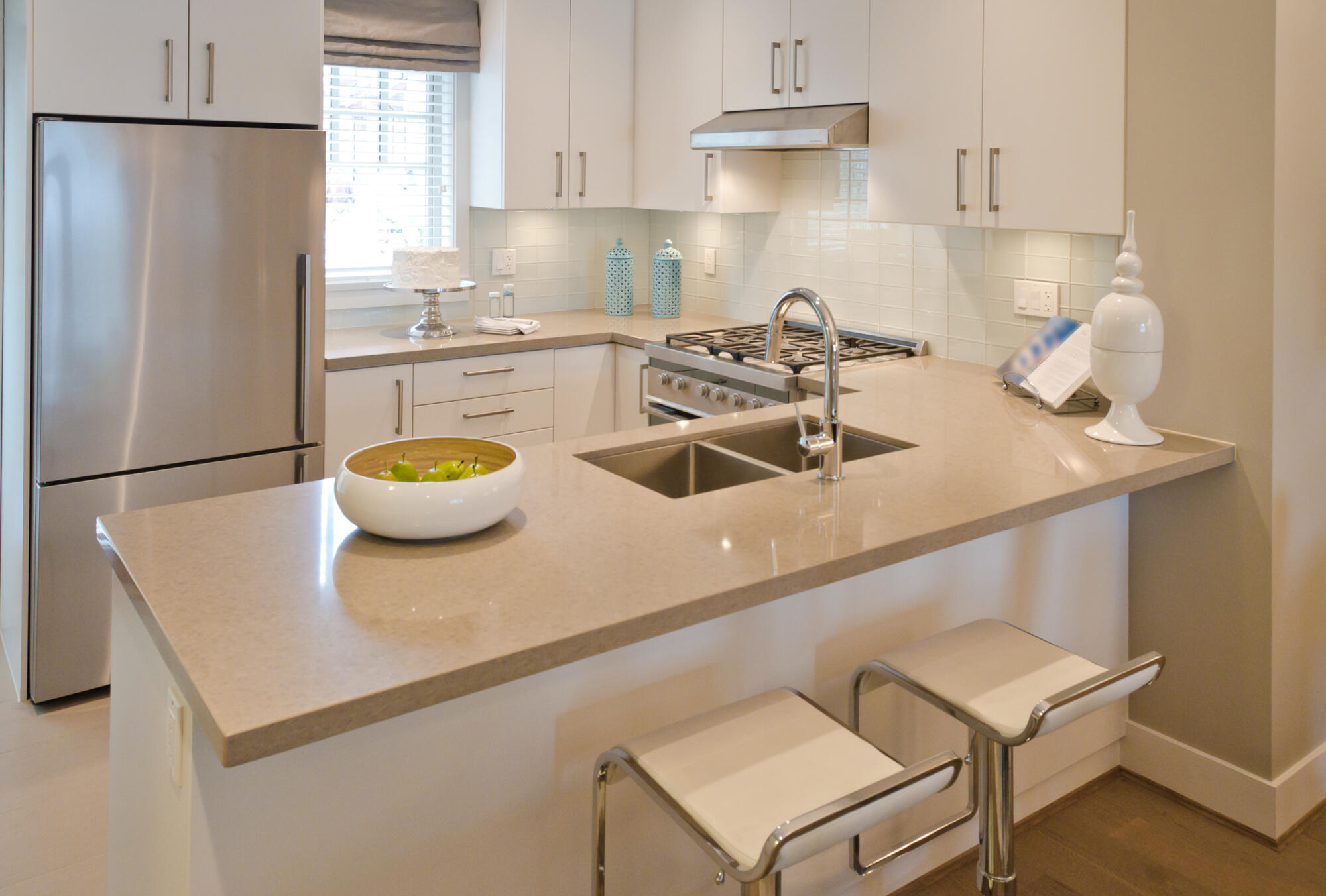 A white kitchen with stainless steel appliances and a kitchen peninsula.