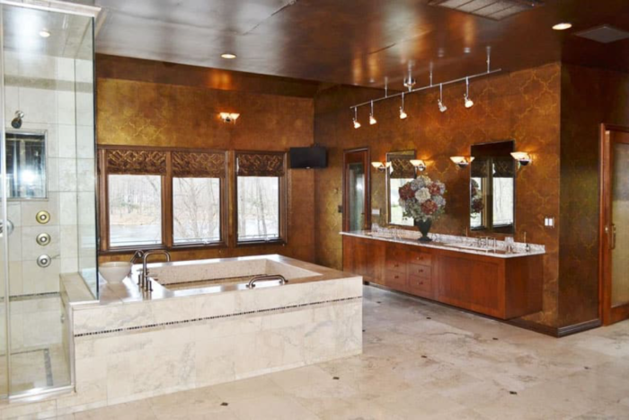 A large Craftsman-style bathroom with brown walls and marble counter tops.