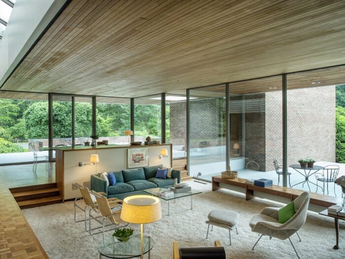 A modern sunken living room with a large glass wall.