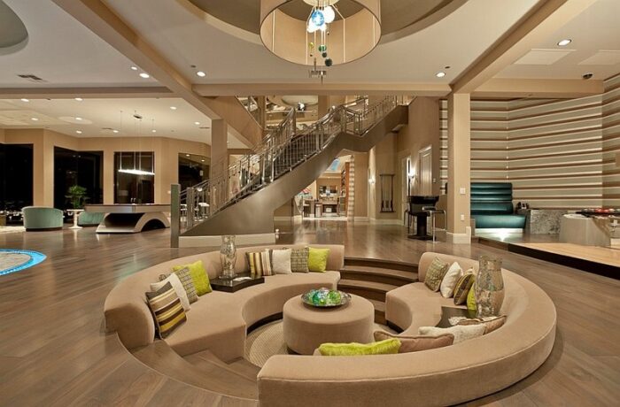 A sunken living room with couches and a circular staircase.