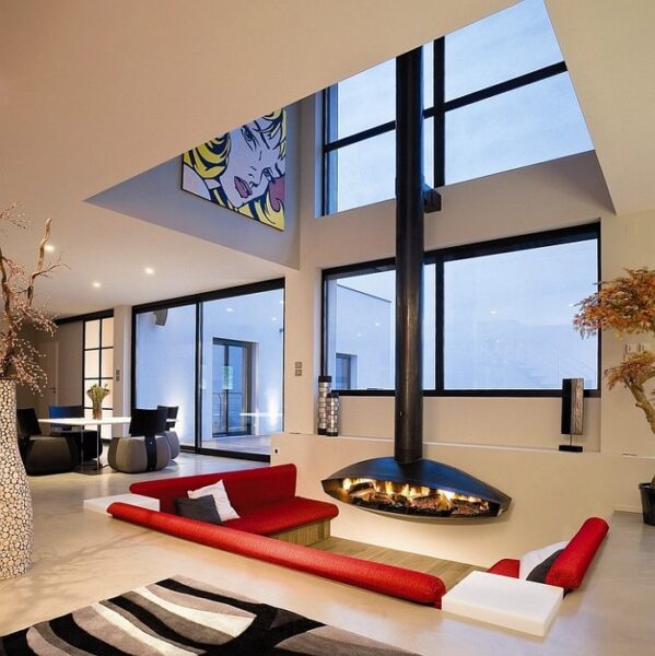 A modern sunken living room with large windows.