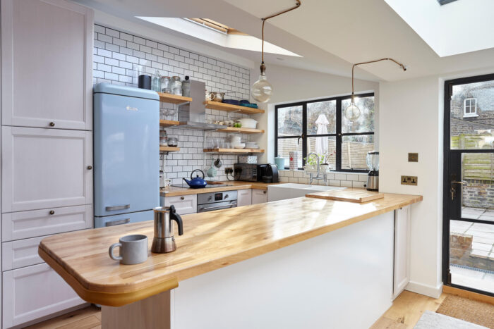 A kitchen with a wooden counter, skylight, and a peninsula.