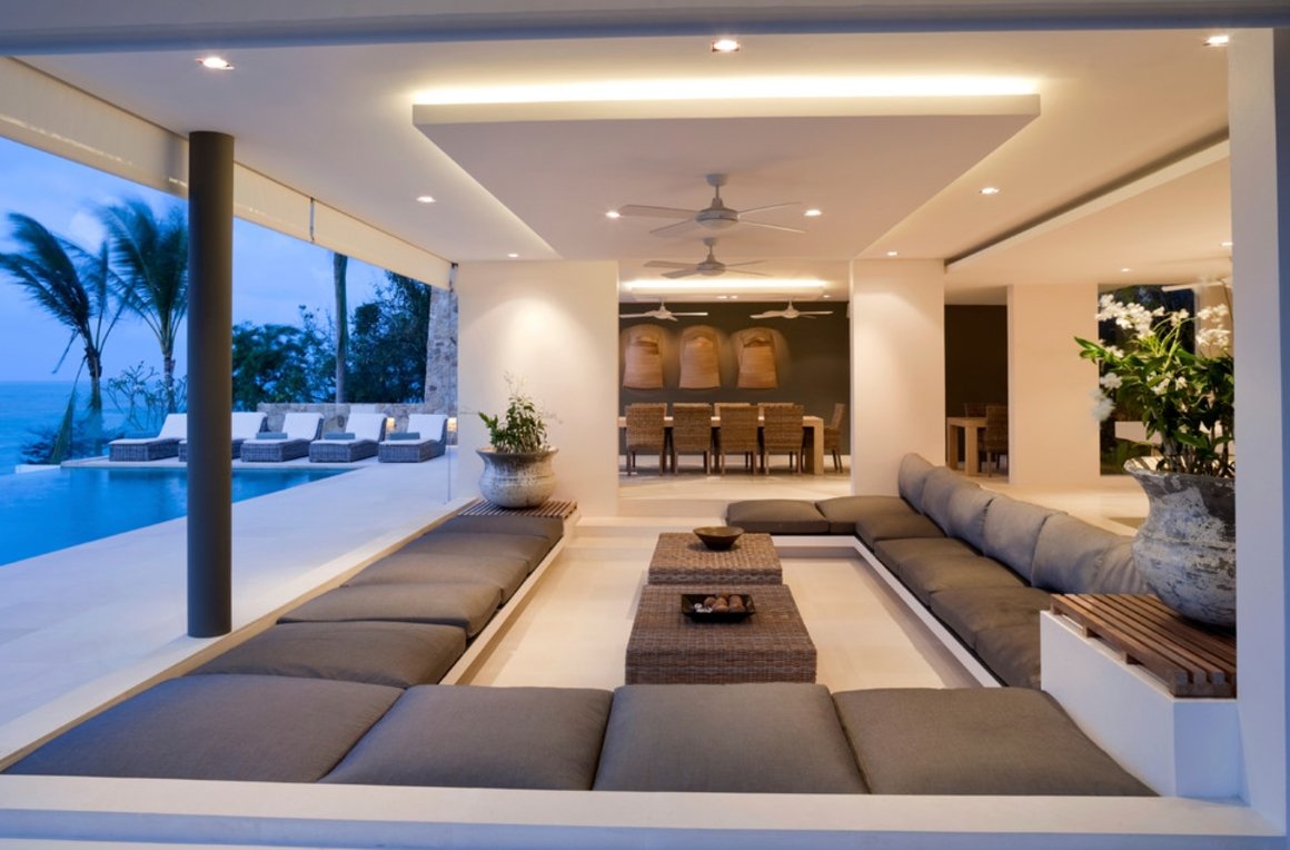 A sunken living room with couches and a large pool.