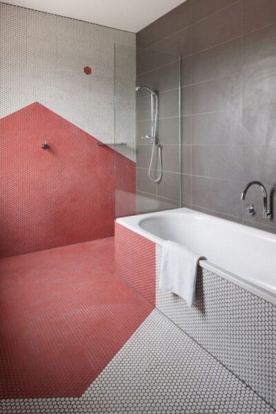 A penny tile bathroom with a red and white tiled floor.