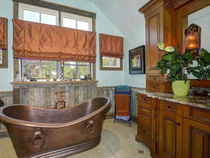 A Craftsman-style bathroom with a copper tub and large windows.