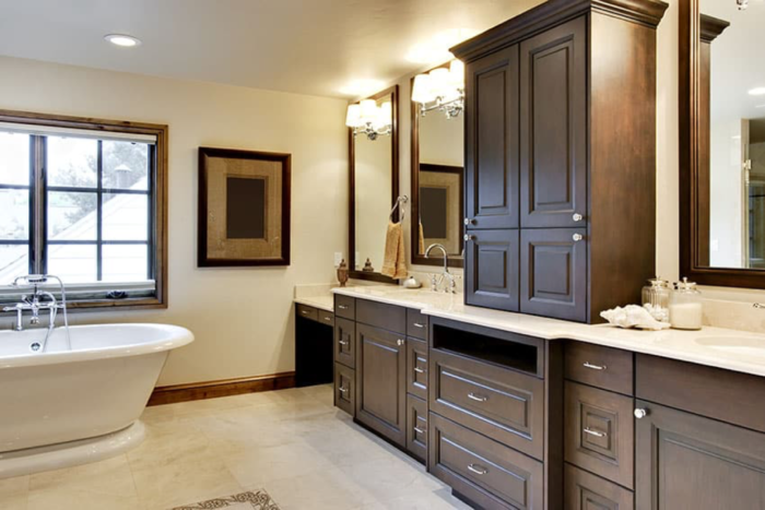 A Craftsman-style bathroom with brown cabinets and a tub.
