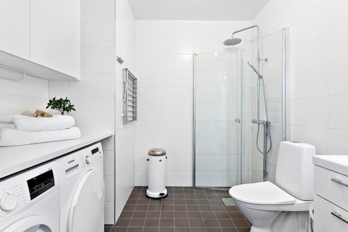 A Scandinavian bathroom with a washer and dryer.
