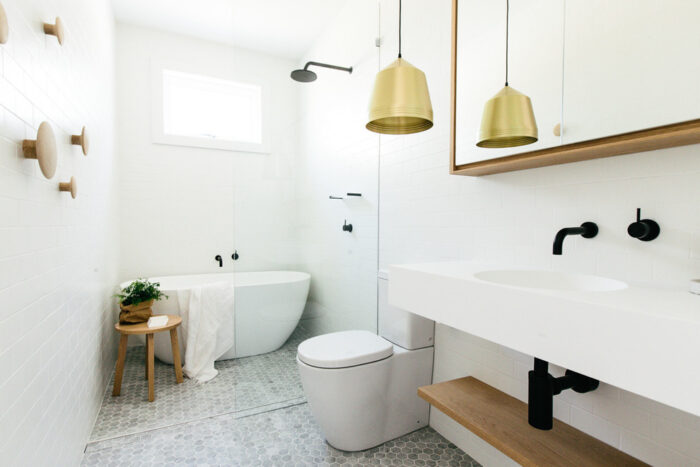A Scandinavian bathroom with a gold pendant light.